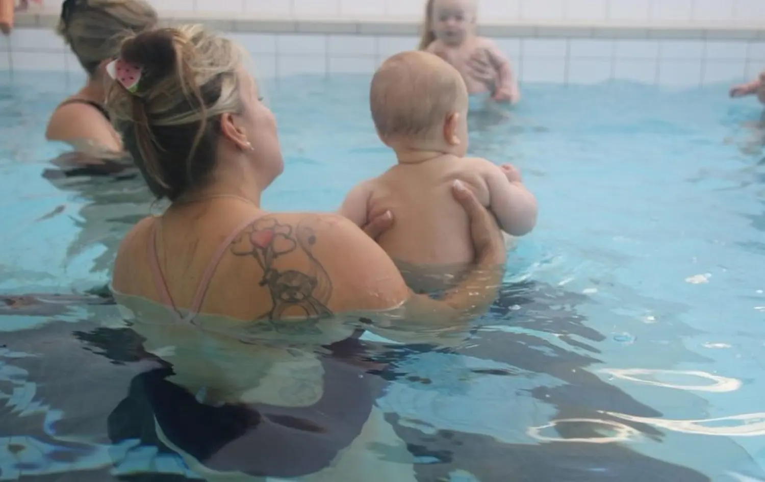 Swimmerfirst, eine Frau hält ein Baby im Wasser