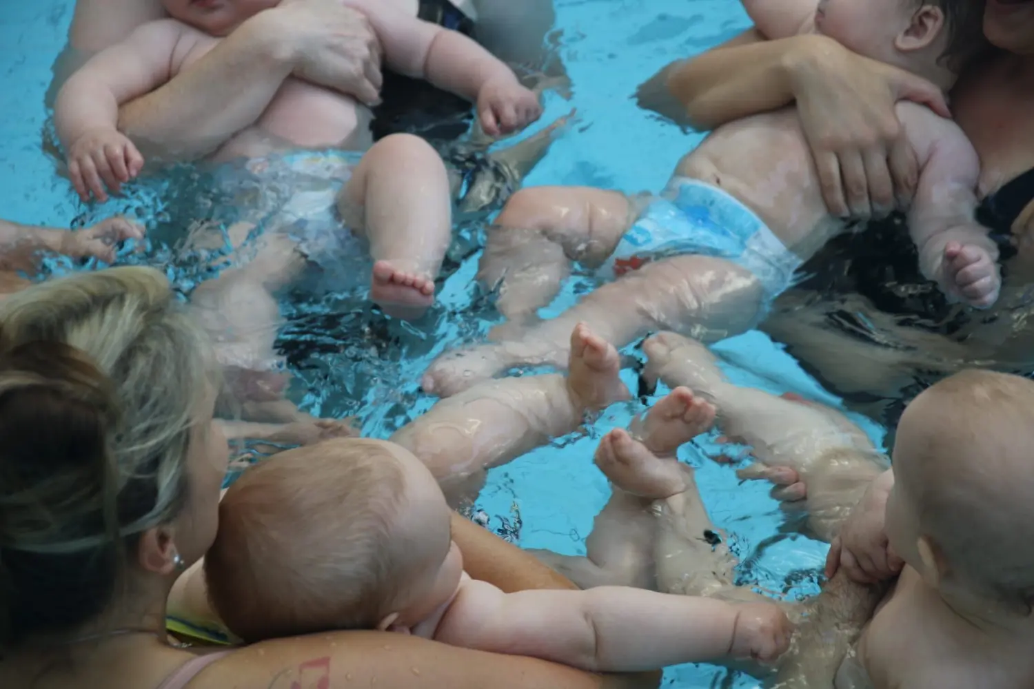 Swimmerfirst, Frauen trainieren Babys im Wasser zum Schwimmen